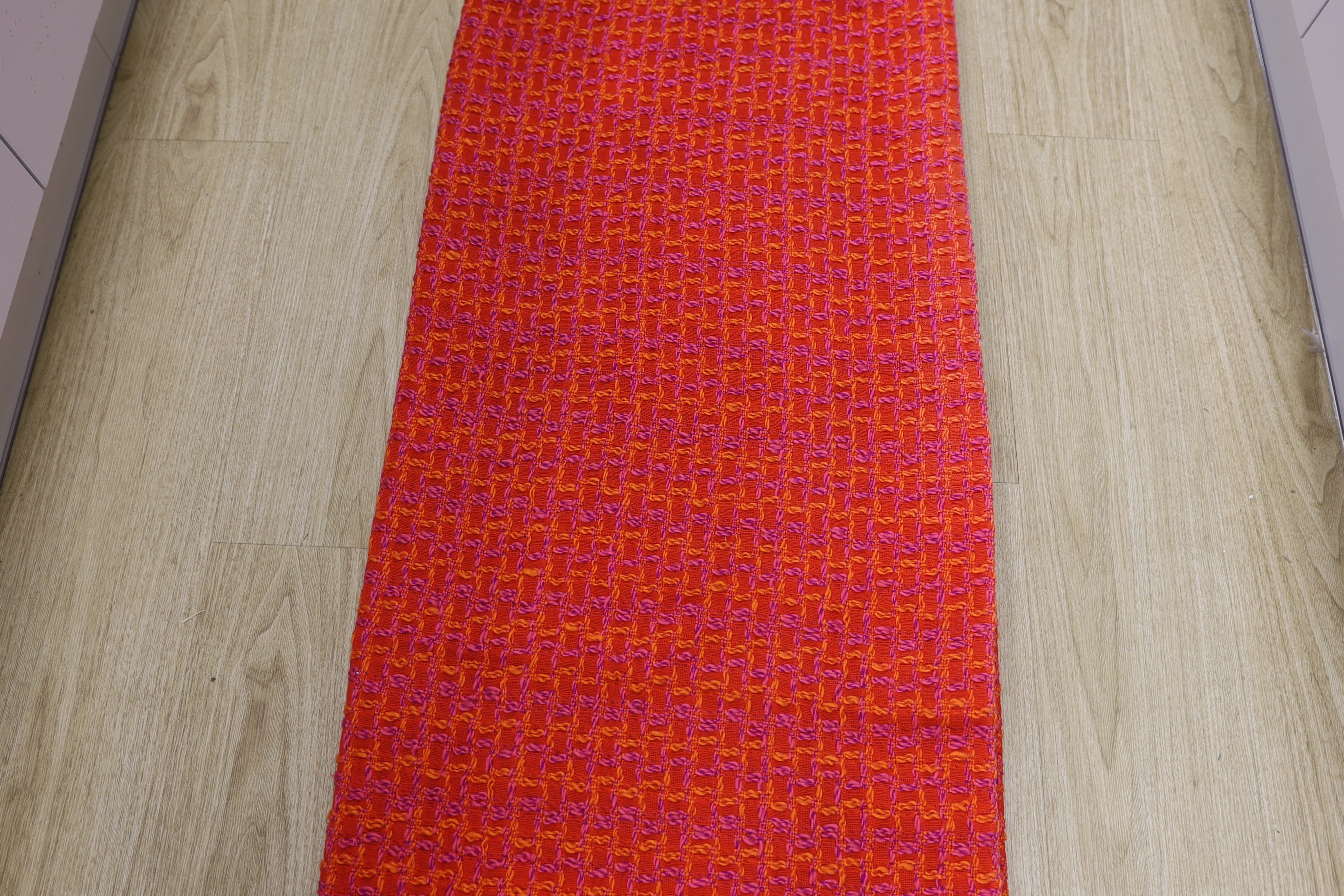 An unusual woven 1960's curtain in orange, pink and purple wools in a square overall pattern